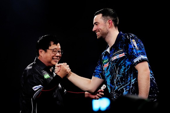 Singapore's Paul Lim shakes hands with England's Luke Humphries after he won a leg on day twelve of the World Darts Championship at the Alexandra Palace, in London, Monday, Dec. 22, 2025. (J ...