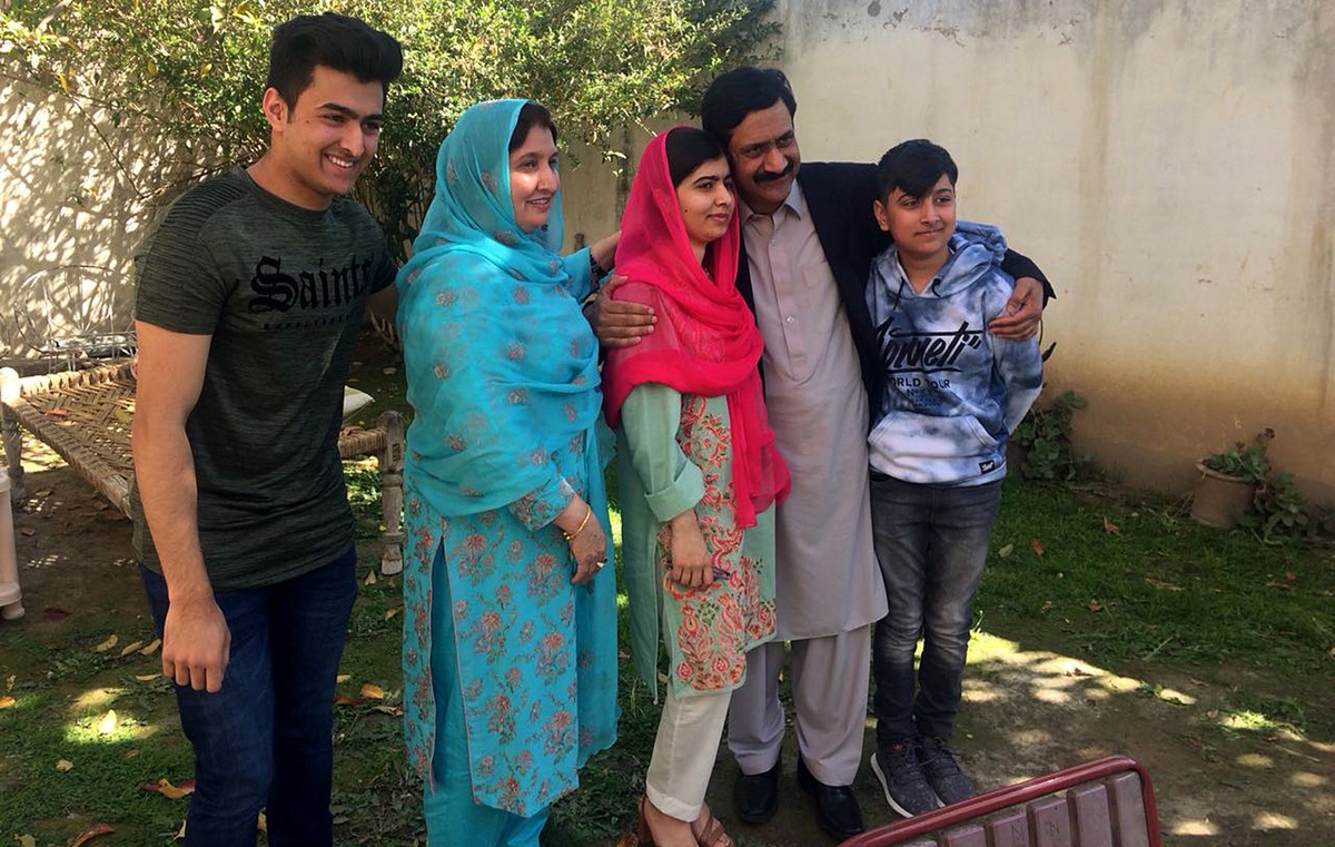 Pakistan's Nobel Peace Prize winner Malala Yousafzai, center, poses for a photograph with her family members at her native home during a visit to Mingora, the main town of Pakistan Swat Valley, S ...