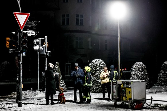 epa12624215 Fire department personnel use a power generator at contact point with local residents at Mexikoplatz square in western Berlin, Germany, 03 January 2026. A major power outage struck western ...