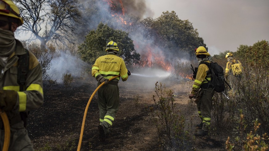Firefighter try to extinguish flames as wildfire advance during a wildfire in Ferreras de Abajo in north western Spain, Monday, July 18, 2022. Firefighters battled wildfires raging out of control in S ...