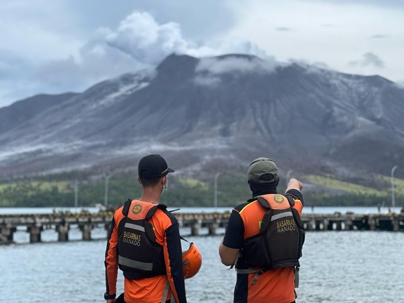 epa11285818 A handout photo made available by National Search and Rescue Agency (BASARNAS) shows rescuers observing Mount Ruang eruption in Tagulandang, Indonesia, 18 April 2024. The Center for Volcan ...