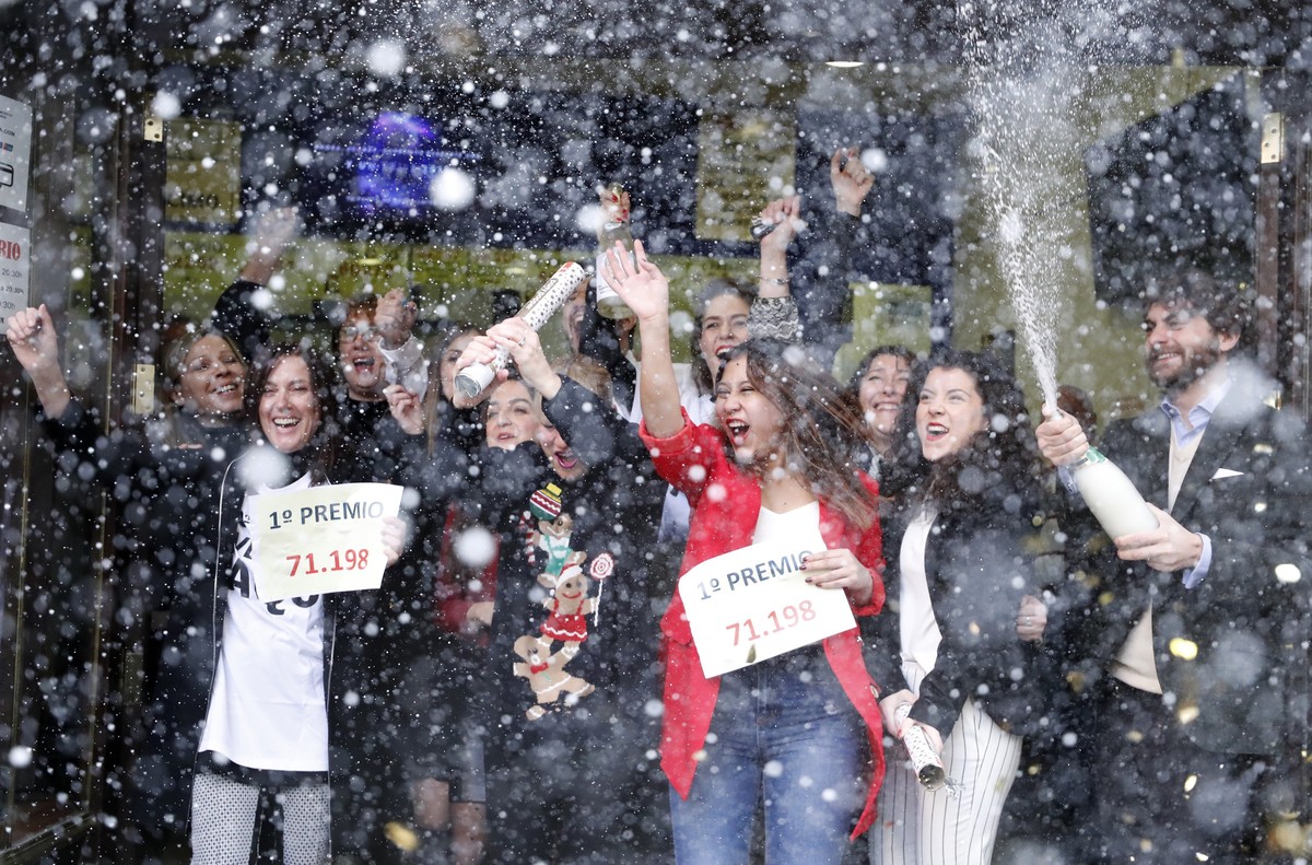 epaselect epa06402927 Workers of the lottery shop 'Dona Manolita' celebrate after learning that they have sold one of the first prize tickets of the El Gordo (The Fat One) lottery in Madrid, ...