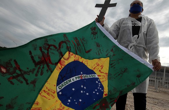 epa09172503 A healthcare worker attends a rally to honor victims of the coronavirus, in front of the Planalto presidential Palace in Brasilia, Brazil, 01 May 2021. EPA/Joedson Alves