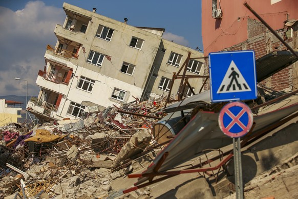 A destroyed building leans on a neighbouring house following the earthquake in Samandag, southern Turkey, Wednesday, Feb. 22, 2023. Survivors of the earthquake that jolted Turkey and Syria 15 days ago ...