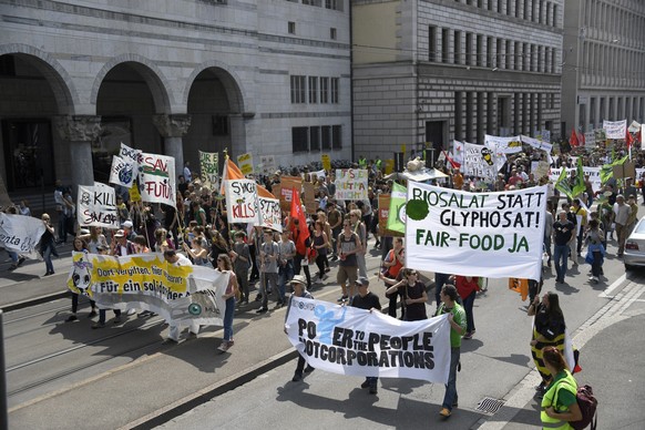 epa06749574 Protesters carry banners during their march against the multinational agrochemical and agricultural biotechnology companies Monsanto and Syngenta in Basel, Switzerland, 19 May 2018. EPA/GE ...