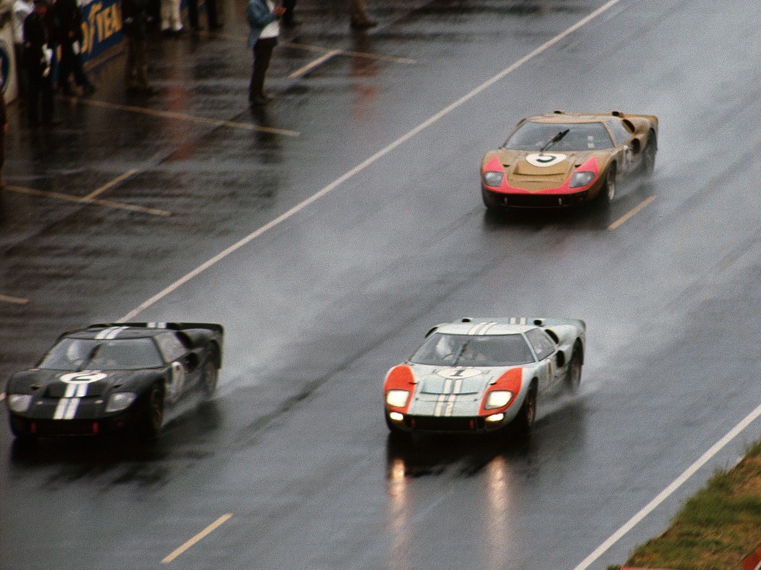 The Le Mans 24 Hours; Le Mans, June 18-19, 1966. Streaking toward the end of the race, the top three Ford GT40 Mk. IIs leave sheets of spray behind them. Leading is the eventually winning n. 2 car of  ...