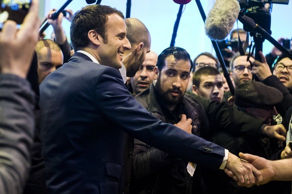 epa06907397 The then French presidential candidate Emmanuel Macron (L) of the &#039;En Marche&#039; political movement flanked by security staff Alexandre Benalla (C) visiting the International Agricu ...