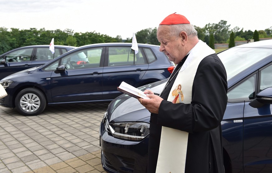 epa05426541 Cardinal Stanislaw Dziwisz stands next to a Volkswagen (VW) Golf car in front of the Divine Mercy Sanctuary in Krakow, Poland, 15 July 2016. The cars have been donated by Volkswagen to the ...