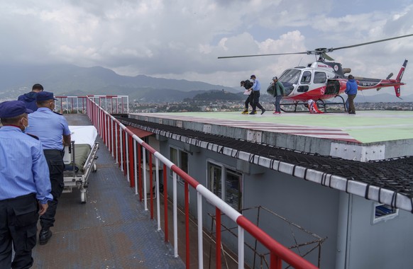 Two Nepali sherpa guides, second right and fourth right, who survived an avalanche at a lower elevation on the world&#039;s eighth-highest mountain Mount Manaslu are taken for treatment after being fl ...