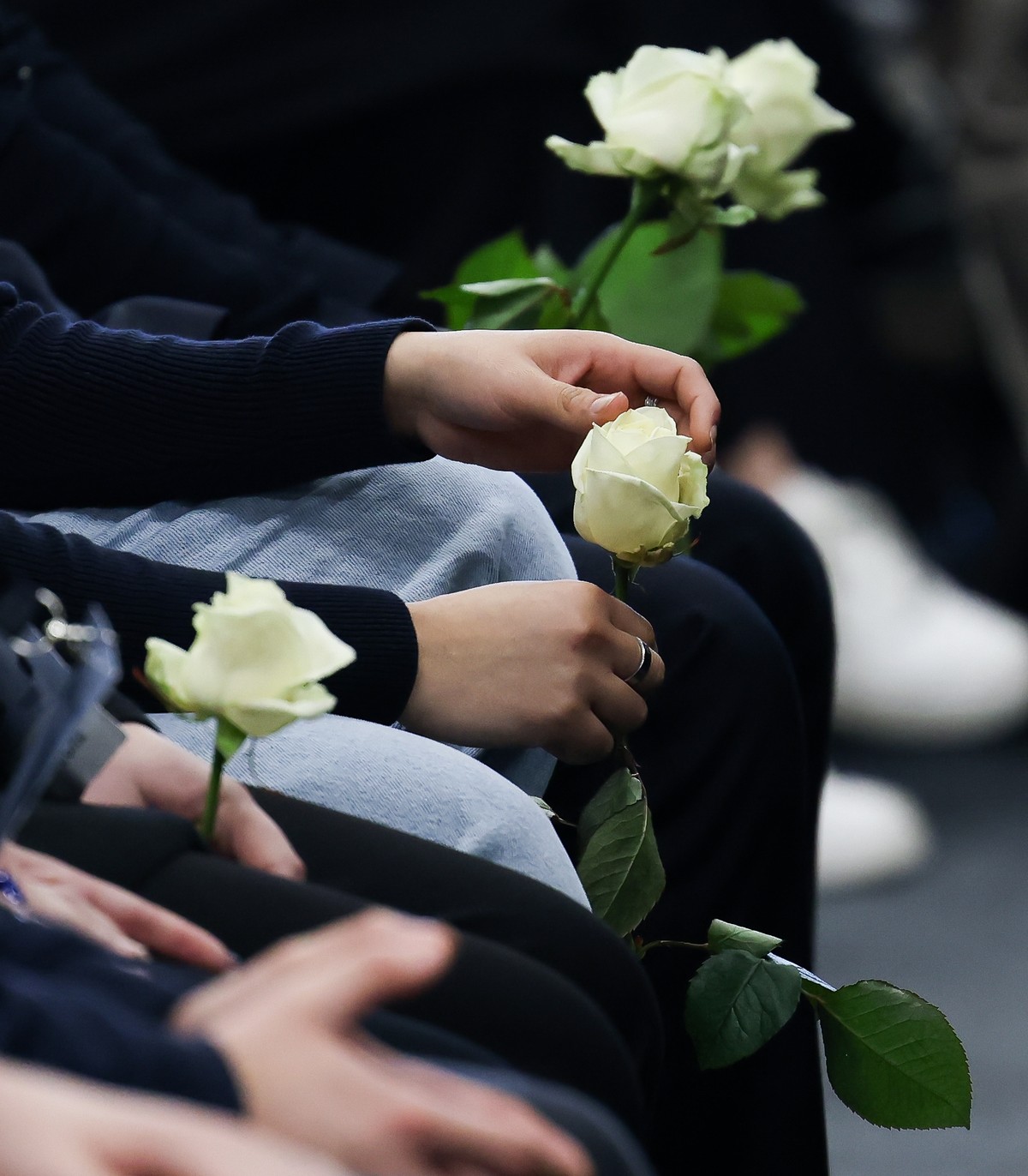 Mourners hold white roses during a national mourning ceremony for the victims of the deadly fire at "Le Constellation" bar during a New Year's Eve party in Crans-Montana, in Martigny, S ...