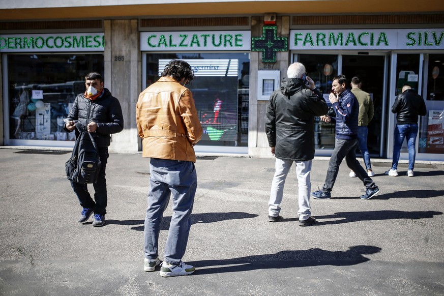 People keep a distance from each other as they queue outside a pharmacy in Rome, Wednesday, March 11, 2020. Italy is mulling even tighter restrictions on daily life and has announced billions in finan ...