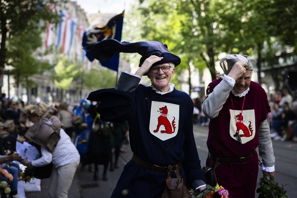 Teilnehmer kaempfen mit dem Wind am traditionellen Umzug der Zuenfte am Zuercher Sechselaeuten, aufgenommen am Montag, 15. April 2024, in Zuerich. (KEYSTONE/Michael Buholzer)