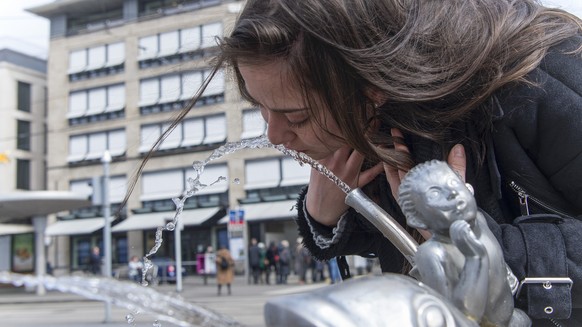 Eine junge Frau trinkt aus einem Trinkbrunnen beim Paradeplatz, fotografiert anlaesslich des Weltwassertag am Donnerstag, 22. Maerz 2018, in Zuerich. (KEYSTONE/Melanie Duchene)