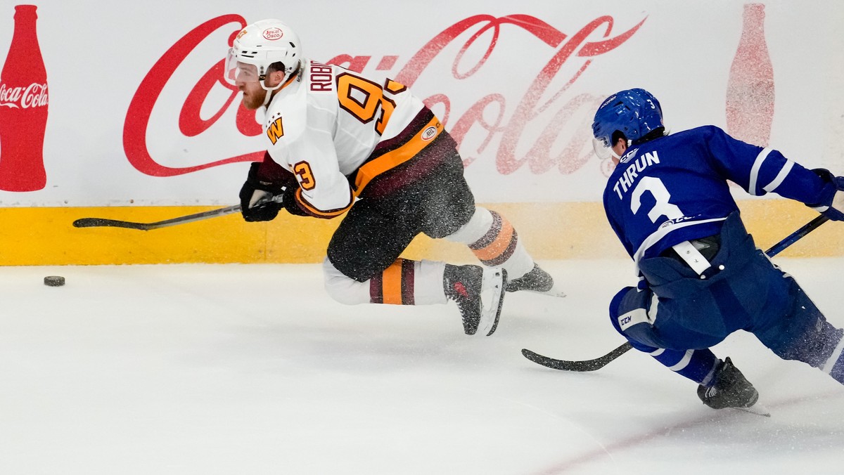 Chicago Wolves centre Justin Robidas (93) is chased by Toronto Marlies defenseman Henry Thrun (3) during the second period in Game 4 of the AHL Calder Cup Final in Toronto on Thursday, June 18, 2026.  ...