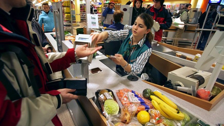 Eine Mann bezahlt am 20. Januar 2005 an einer Kasse im Migros Limmatplatz in Zuerich seine Einkaeufe. Migros zaehlt zu den groessten Anbietern in der Schweiz. Das Verkaufsnetz umfasst insgesamt 587 St ...