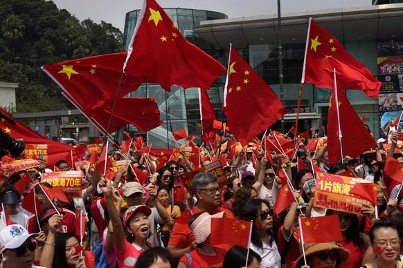 Pro-China supporters wave Chinese national flags at the Peak in Hong Kong Sunday, Sept. 29, 2019. Hundreds of pro-Beijing supporters sang Chinese national anthem and waved red flags ahead of China&#03 ...