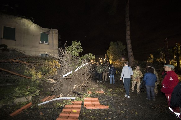 epa05620387 People work to clear debris and fallen trees that lay on the road due to the tornado that hit Cesano, 30 km north of Rome, Italy, 06 November 2016. EPA/MASSIMO PERCOSSI