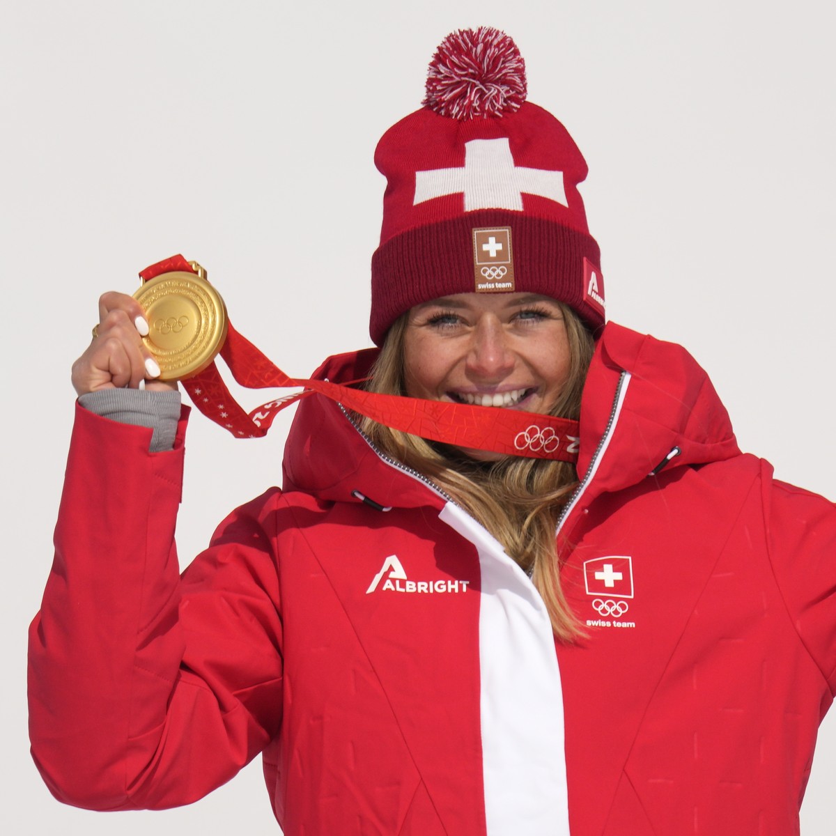 Corinne Suter, of Switzerland, gold, reacts during the medal ceremony for the women's downhill at the 2022 Winter Olympics, Tuesday, Feb. 15, 2022, in the Yanqing district of Beijing. (AP Photo/L ...