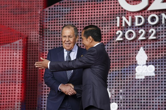 Russian Foreign Minister Sergey Lavrov greets Indonesia&#039;s President Joko Widodo as he arrives for the G20 leaders&#039; summit in Nusa Dua, Indonesia, Tuesday, Nov. 15, 2022. (Kevin Lamarque/Pool ...