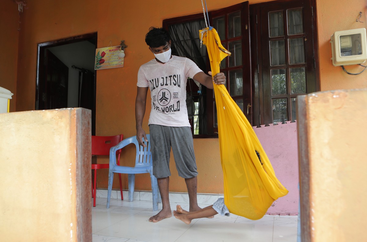 Sri Lankan auto rickshaw driver Prasad Dinesh, linked by Sri Lankan officials to nearly half the country's more than 2,600 coronavirus cases, pushes his daughter in a swing at their home in Ja-El ...