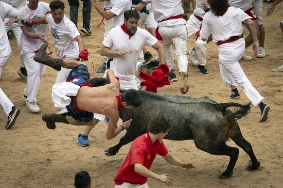 epa10731433 A mozo or runner is turned upside down by a young calf at the bullring at the end of the first bull run of Sanfermines 2023 in Pamplona, northern Spain, 07 July 2023. Pamplona&#039;s Runni ...