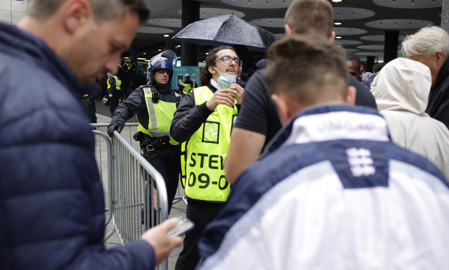 Stewards check for electronic tickets of fans as they enter Wembley Stadium in London, Sunday, July 11, 2021, prior to the Euro 2020 soccer championship final match between England and Italy. (AP Phot ...