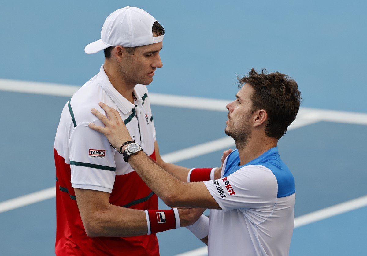 John Isner, left, of the U.S. shakes hands with Switzerland's Stan Wawrinka after retiring from their third round match at the Australian Open tennis championship in Melbourne, Australia, Saturda ...