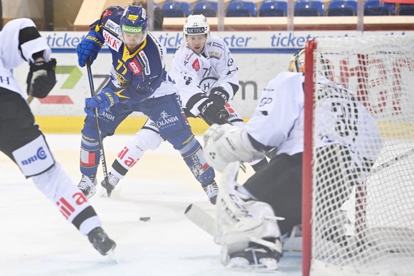 Davos&#039; Teemu Turunen scheitert an Luganos Tim Heed und Luganos Torhueter Niklas Schlegel, von links, beim Eishockey-Qualifikationsspiel der National League zwischen dem HC Davos und dem HC Lugano ...
