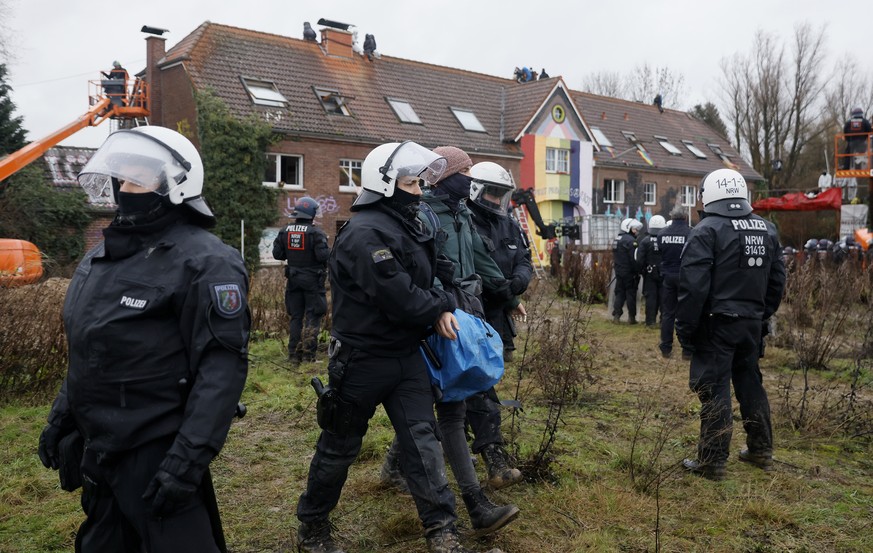 epa10401570 Police officers detain an activist during a clearing operation in the village of Luetzerath, Germany, 12 January 2023. The village of Luetzerath in North Rhine-Westphalia state is to make  ...