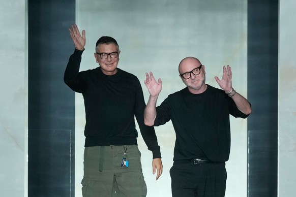 Italian stylists Stefano Dolce, left, and Domenico Gabbana arrive on the catwalk at the end of the presentation of their Fall/Winter 2026-2027 Men's collection, in Milan, Italy, Saturday, Jan. 17 ...