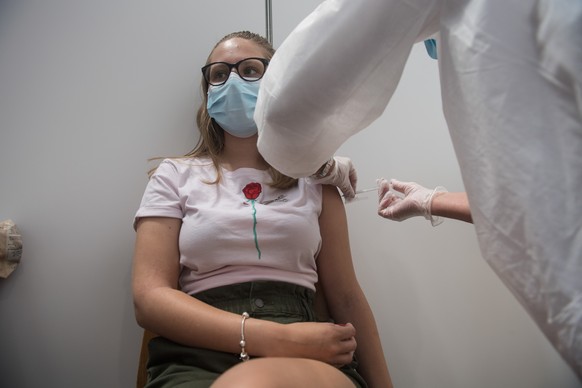 Eine junge Frau erhaelt im Impfzentrum von Giubiasco am Dienstag, 29. Juni 2021 ihre Corona-Impfung. Im Tessin werden zurzeit junge Leute in zwei Gruppen fuer unter 16-Jaehrige und ueber 16-Jaehrige g ...