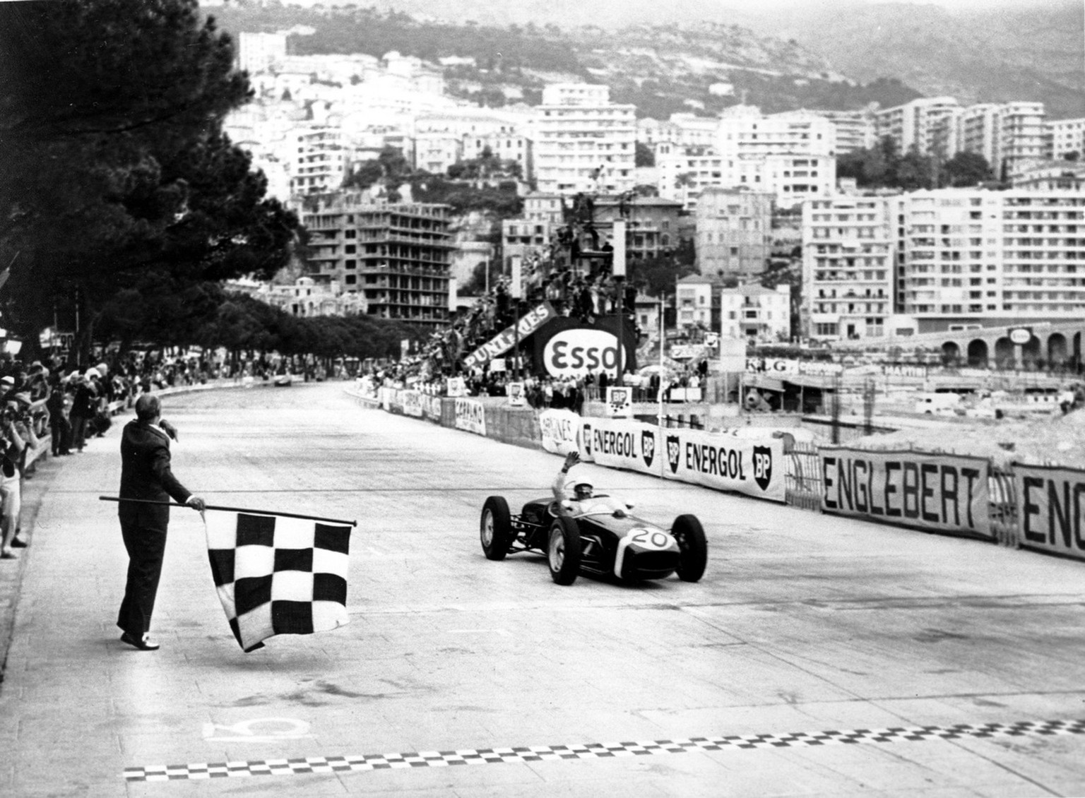 Winkend überquert der Brite Stirling Moss&nbsp;1961 als Sieger des Formel-1-GP von Monaco die Ziellinie.