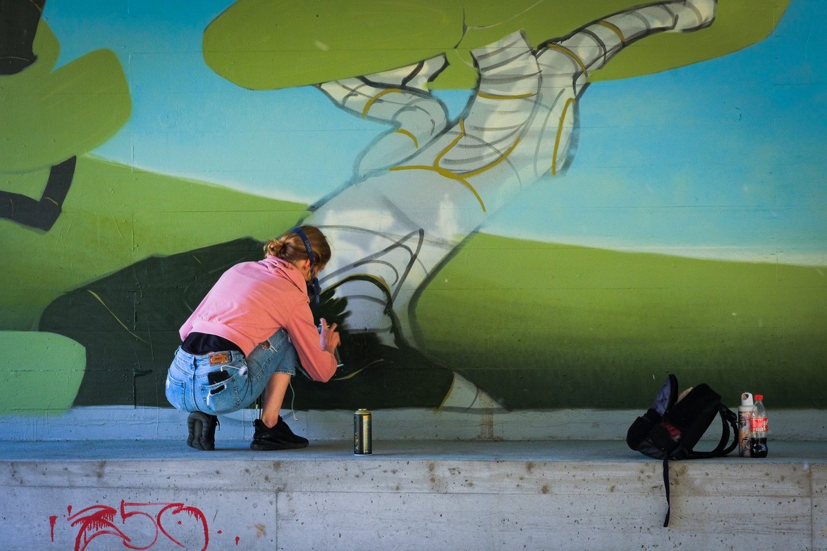 Streetart Festival 2023 – Frau sprayt unter einer Strasse, 03.06.2023
