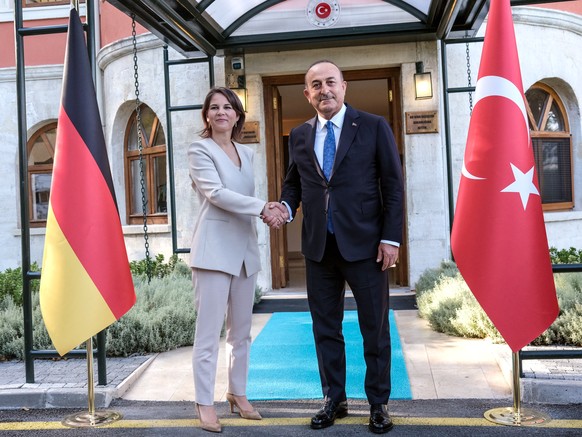 epa10097389 Turkish Minister of Foreign Affairs Mevlut Cavusoglu (R) shakes hands with German Foreign Minister Annalena Baerbock (L) before their meeting in Istanbul, Turkey, 29 July 2022. Baerbock is ...