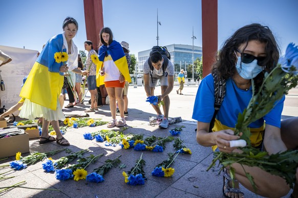 epa10047721 Protesters lay flowers during a demonstration against the Russian invasion of Ukraine in front of the Palais des Nations during a Russian demonstration against the war in Ukraine in Geneva, Switzerland, 02 July 2022.  EPA/MARTIAL TREZZINI