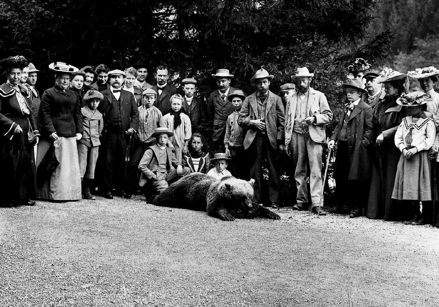 Zwei Buendner Jaeger, 7. und 9. Person von rechts, posieren am 1. September 1904 in Scuol im Engadin mit dem letzten Baeren der Schweiz, umringt von einer Schar von Dorfbewohnern, die alle das Ereigni ...