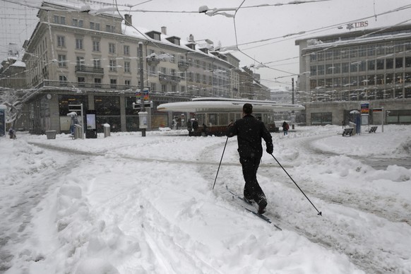 A man on cross-country skis crosses the Paradeplatz in the financial center of Zurich after heavy snowfalls in Zurich, Switzerland, Friday, January 15 2020. The traffic situation is difficult after pe ...