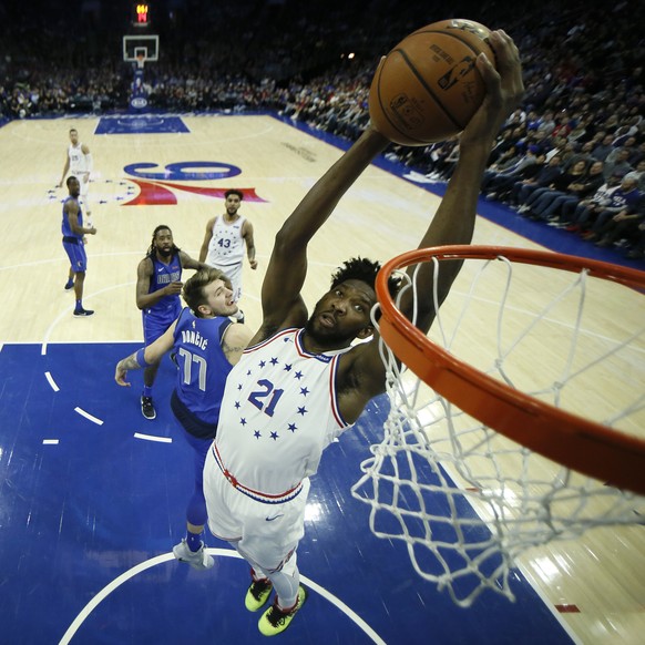Philadelphia 76ers' Joel Embiid (21) goes up for a dunk past Dallas Mavericks' Luka Doncic (77) during the first half of an NBA basketball game, Saturday, Jan. 5, 2019, in Philadelphia. (AP ...