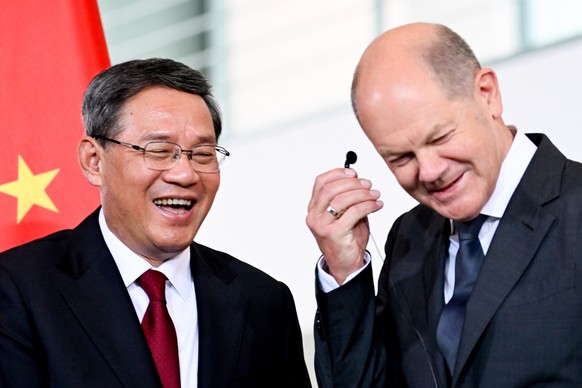 epa10701486 German Chancellor Olaf Scholz (R) and Chinese Premier Li Qiang smile after a press conference during the 7th German-Chinese Government Consultation at the Chancellery in Berlin, Germany...