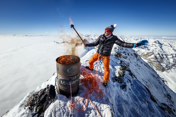 Pirmin Zurbriggen, former alpine ski racing champion from Switzerland, lights a symbolic torch in support of the &quot;Sion 2026&quot; winter Olympic Games candidacy project, on the summit of the Matt ...