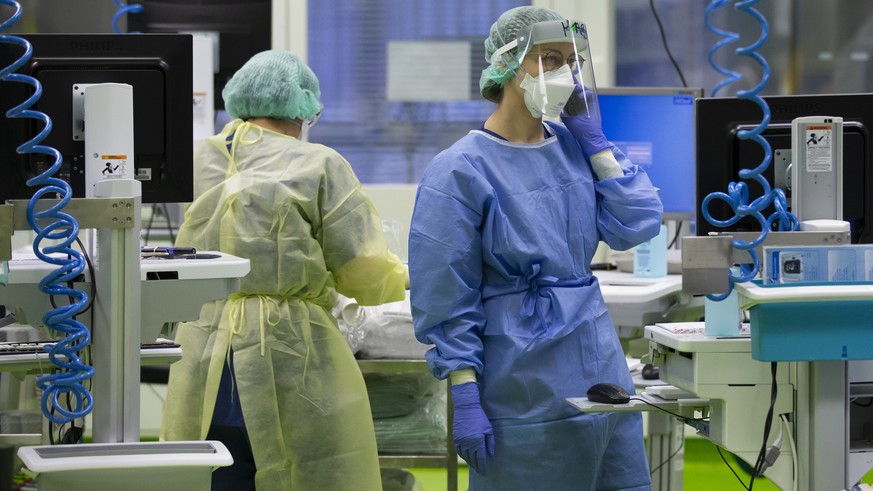 Aerzte und Pflegende kuemmern sich um Covid-Patienten in einer Intensivstation im Universitaetsspital Basel, am Montag, 28. Dezember 2020, in Basel. (KEYSTONE/Peter Klaunzer)