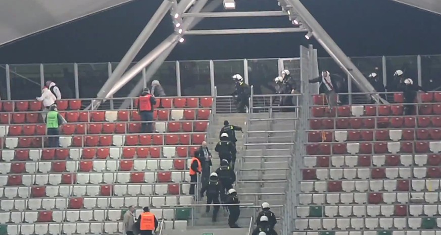 Ein wenig verspätet kann die Polizei die Jagiellonia-Fans aus der Umklammerung befreien. Das Spiel musste abgebrochen werden. Wie die Partie ausgeht, wird die Liga noch entscheiden.