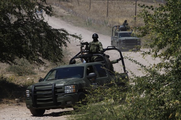 Mexican soldiers patrol near Naranjo de Chila in the municipality of Aguililla, Mexico, Friday, Feb. 18, 2022. The town had been the scene of a bloody turf battle between two drug cartels. Earlier thi ...