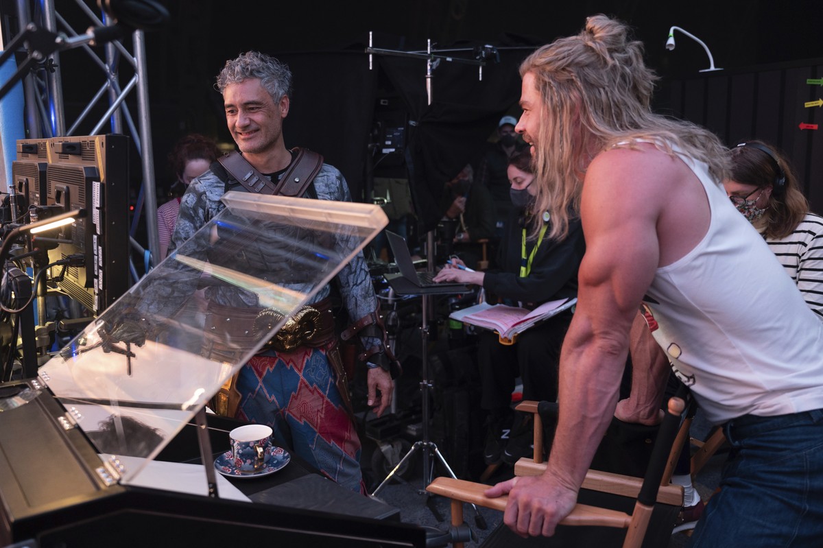 This image released by Marvel Studios shows director Taika Waititi, left, and Chris Hemsworth on the set of "Thor: Love and Thunder." (Jasin Boland/Marvel Studios via AP)