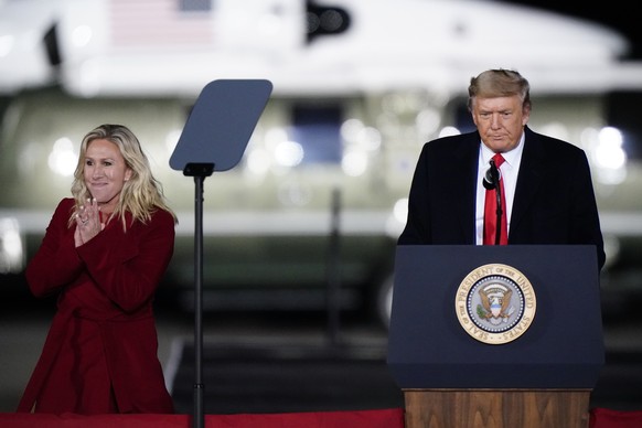 Rep. Marjorie Taylor Greene, R-Ga., smiles as President Donald Trump speaks at a campaign rally in support of Senate candidates Sen. Kelly Loeffler, R-Ga., and David Perdue in Dalton, Ga., Monday, Jan ...