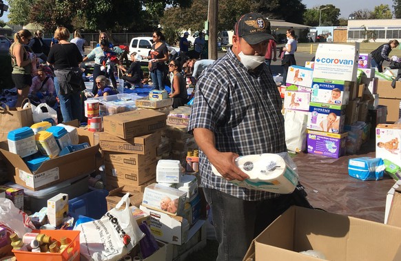 FILE -- In this Oct. 17, 2017 file photo wildfire evacuee Gonzalo Jauregui, a local grape picker, browses through donated toiletries at the Sonoma-Marin Fairgrounds in Petaluma, Calif. The deadliest a ...