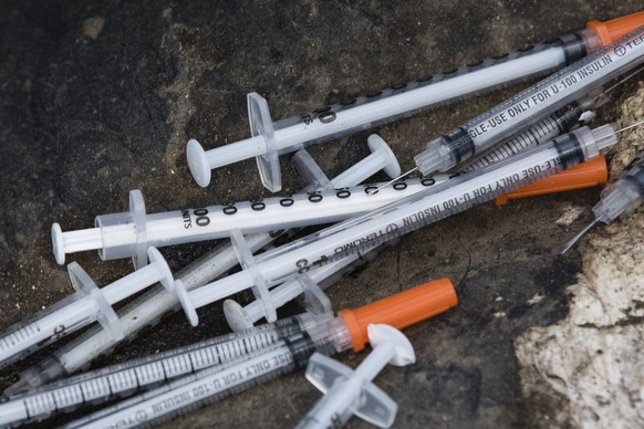 FILE - This July 31, 2017, file photo shows discarded syringes in an open-air heroin market that has thrived for decades, slated for cleanup along train tracks a few miles outside the heart of Philade ...