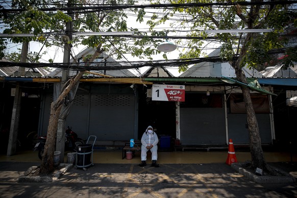 epa08317393 A man wearing a protective suit and mask takes a break from spraying disinfectant on vehicles entering the Chatuchak market, in an effort to prevent the spread of the COVID-19 disease caus ...