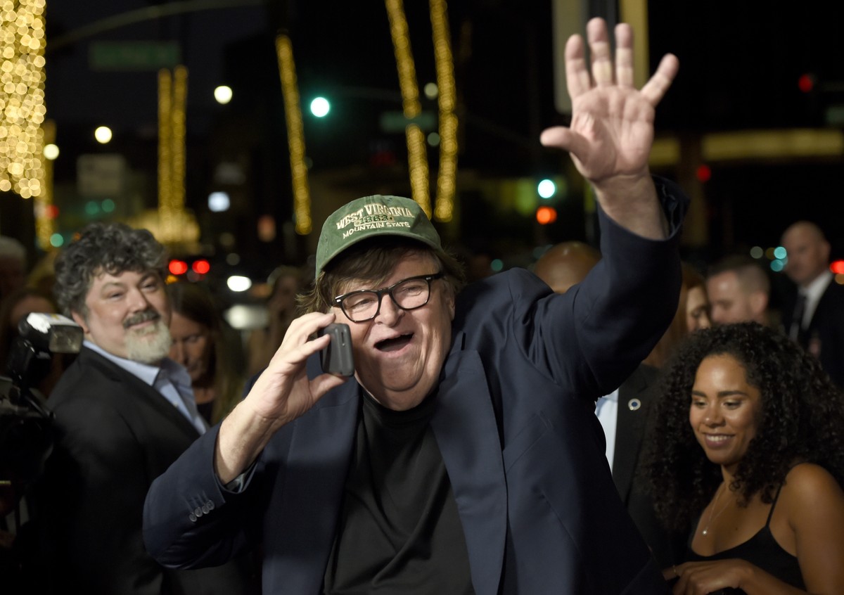 Michael Moore waives to Omarosa Manigault Newman as he arrives at the premiere of "Fahrenheit 11/9" on Wednesday, Sept. 19, 2018, at the Samuel Goldwyn Theater in Beverly Hills, Calif. (Phot ...