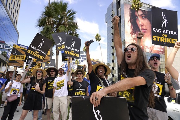 SAG-AFTRA member John Schmitt, second from right, and others carry signs on the picket line outside Netflix on Wednesday, Sept. 27, 2023, in Los Angeles. (AP Photo/Chris Pizzello)
John Schmitt